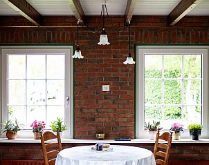 Eethoek in Het Rge Landje vakantiehuis Dennenbos Texel met uitzicht op de tuin.