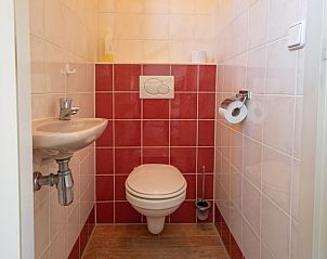 Separate Toilette im Ferienhaus 8690 - Junier - Huisman, Sd-Eierland, Texel, mit roten und weien Fliesen fr einen frischen Look.