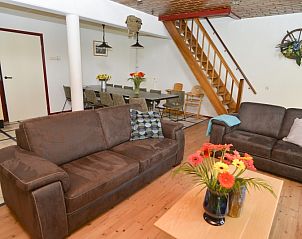 Gerumiges Wohnzimmer im Ferienhaus De Oorsprong, Zuid-Eierland, Texel mit bequemen Sofas und Essecke.