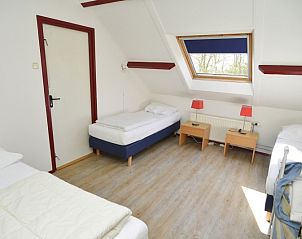 Schlafzimmer mit Dachfenster im Ferienhaus De Oorsprong, Zuid-Eierland, Texel mit drei Einzelbetten.