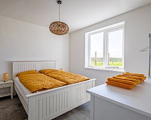 Attraktives Schlafzimmer im Ferienhaus De Noordbunder, Zuid-Eierland, Texel mit Blick auf die Natur.