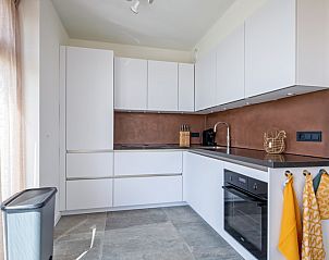 Moderne Kche in der Ferienunterkunft De Zuidbunder auf Texel mit schlichten weien Schrnken.