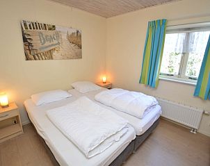 Gezellige tweepersoons slaapkamer in Vakantiehuis De Nagtegaal 15, De Wulk, Texel met stranddecor.