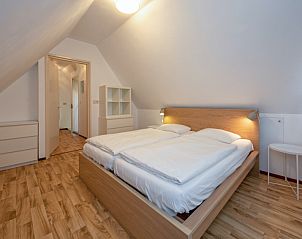 Tweede slaapkamer in Huisje 7, De Dennen, Texel met houten vloer en knusse sfeer voor een ontspannen verblijf op de Waddeneilanden.