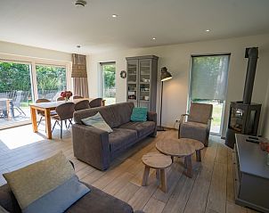 Lichte woonkamer van Vakantiehuis de Parel 150 in De Dennen, Texel met uitzicht op de tuin.