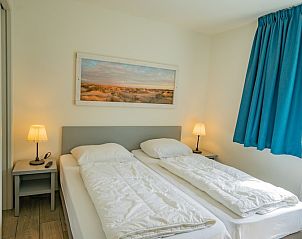 Slaapkamer in Vakantiehuis de Parel 150 in De Dennen, Texel met tweepersoonsbed en serene sfeer.