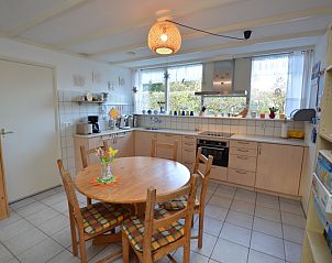 Gerumige Kche im Ferienhaus de Parel 212, De Dennen Texel mit Esstisch und Blick auf die Natur.