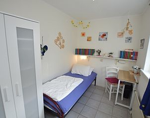 Schlafzimmer im Ferienhaus de Parel 212, De Dennen Texel mit Einzelbett und Schreibtisch.