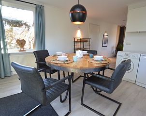 Essecke im Bungalowpark Vredelust, De Dennen, Texel, mit Blick auf den grnen Garten und die moderne Einrichtung.