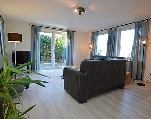 Helles Wohnzimmer im Bungalowpark Vredelust, De Dennen, Texel, mit Zugang zum Garten und modernen Mbeln.