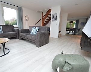 Gerumiger Wohnraum im Ferienhaus Bungalowpark Vredelust, De Dennen, Texel, mit offener Treppe zum Obergeschoss.