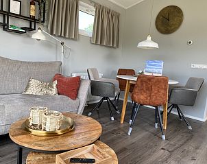 Eetgedeelte van Vakantiepark de Bremakker - Bosveld 148 in De Dennen, Texel met stijlvolle stoelen en warme sfeer.