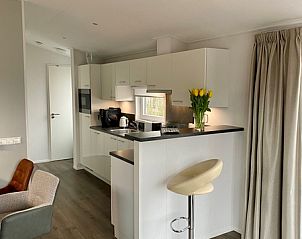 Moderne keuken in Vakantiepark de Bremakker - Bosveld 148, De Dennen, Texel met bar en frisse uitstraling.