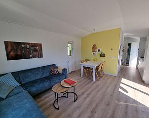 Gemtliches Wohnzimmer im Ferienpark de Bremakker, Bosveld 135, De Dennen, Texel, mit bequemem Sofa und Essecke.