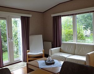 Gezellige woonkamer van Vakantiepark de Bremakker - Bosveld 104 met uitzicht op de tuin in De Dennen, Texel.