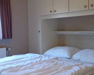 Slaapkamer met tweepersoonsbed in Vakantiepark de Bremakker - Bosveld 104, perfect voor ontspanning in De Dennen, Texel.