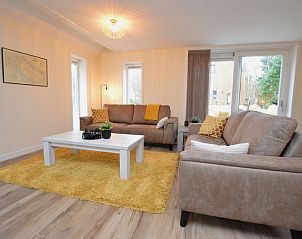 Helles Wohnzimmer im Ferienhaus De Nagtegaal 23, De Dennen Texel, mit moderner Einrichtung und Blick auf den Garten.