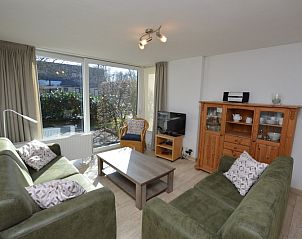 Bright sitting area in Holiday home the Pearl 198 in De Dennen, Texel with views of the green surroundings and comfortable furniture.