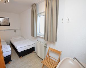 Comfortable bedroom with two beds in Holiday home de Parel 198 in De Dennen, Texel, perfect for a good night's sleep.