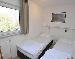 Cozy bedroom in Holiday Home de Parel 198 in De Dennen, Texel with two single beds and views of nature.
