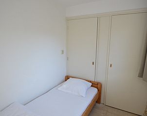 Simple single room in Holiday Home de Parel 198 in De Dennen, Texel with white interior and practical storage space.