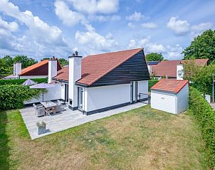 Buitenkant van Vakantiehuis Gortersmient 304, De Dennen, Texel met charmant terras en groene omgeving.