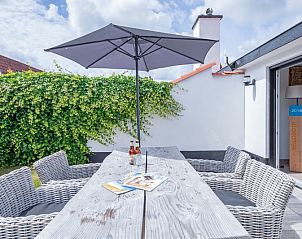 Eettafel met parasol op het terras van Vakantiehuis Gortersmient 304, De Dennen, Texel.