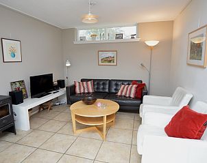 Stylish living room of Bungalow Uterste Coogh 78 in De Dennen, Texel, with modern furnishings and lots of natural light.