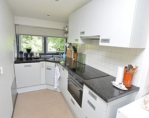 Moderne keukenfaciliteiten in Vakantiehuis 't Hoogelandt 202 - Aan Zee, Texel, met uitzicht op de tuin.