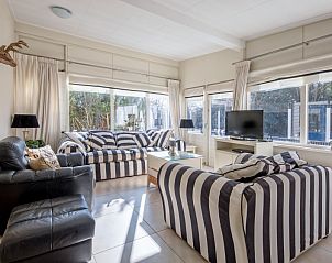 Ruime woonkamer van Bungalowpark 't Hoogelandt, Texel, met grote ramen en veel natuurlijk licht.