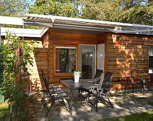 Veranda van Vakantiehuis De Nagtegaal 19 in De Dennen Texel met houten gevel en tuinmeubilair.