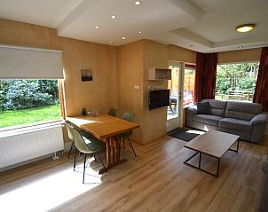 Lichte woonruimte van Vakantiehuis De Nagtegaal 19 in De Dennen Texel met uitzicht op groene tuin.