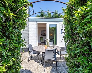 Eethoek met uitzicht op de tuin in Bungalowpark 't Luwe Land - 7B - De Wijnhof, Texel, met veel natuurlijk licht.