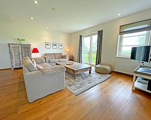 Gezellige woonkamer in Appartement Bos en Duin 40, De Dennen, Texel met comfortabele zithoek en uitzicht op de natuur.