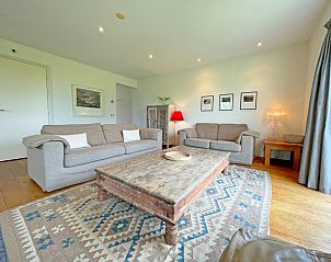 Stijlvolle zithoek in Appartement Bos en Duin 40, De Dennen, Texel met houten vloer en uitnodigende sfeer.