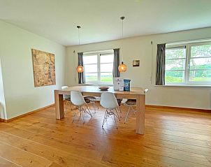 Eetgedeelte in Appartement Bos en Duin 40, De Dennen, Texel met grote eettafel en uitzicht op de buitenomgeving.