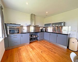 Moderne keuken in Appartement Bos en Duin 40, De Dennen, Texel met roestvrijstalen afwerking en veel opbergruimte.