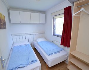 Comfortabele slaapkamer in Vakantiehuis de Parel 222, Texel met aangenaam licht en opbergruimte.