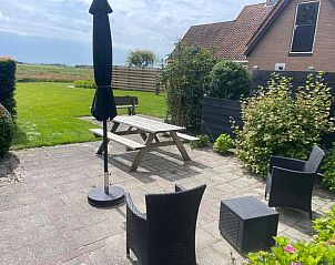 Gerumige Terrasse des Ferienhauses Wollewei De Dennen Texel mit Blick auf grne Felder.