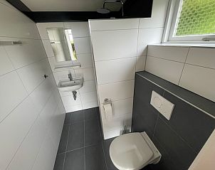 Modernes Badezimmer des Ferienhauses Wollewei De Dennen Texel mit schlichter Einrichtung.