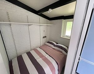 Gemtliches Schlafzimmer im Wollewei-Ferienhaus De Dennen Texel mit bequemem Bett.