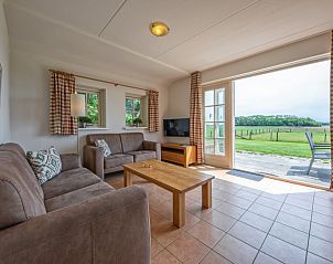 Gezellige woonkamer van 't Mienthuis - De Jonker in De Dennen, Texel met uitzicht op groene velden.