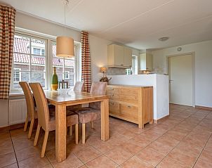 Eetgedeelte van 't Mienthuis - De Jonker, vakantiehuis in De Dennen, Texel met houten tafel en uitzicht.