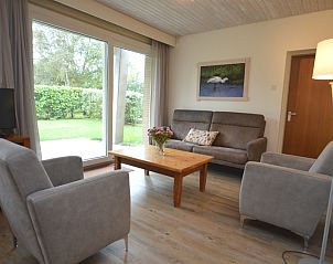 Helle Sitzecke im Ferienhaus Narcis, De Dennen Texel mit Blick auf den Garten.