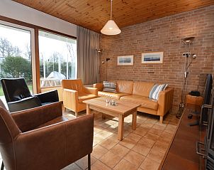 Gemtliches Wohnzimmer im Ferienhaus de Parel 204, De Dennen, Texel mit bequemen Sitzgelegenheiten.