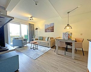 Gemtliches Wohnzimmer im Appartement Bos en Duin 14, De Dennen, Texel mit bequemer Sitzecke und viel Tageslicht.