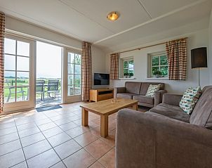 Gezellige woonkamer in 't Mienthuis - Jonkvrouw, vakantiehuis De Dennen, Texel met uitzicht op de natuur van de Waddeneilanden.