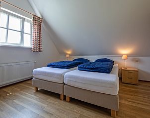 Comfortabele slaapkamer in 't Mienthuis - Jonkvrouw, De Dennen, Texel, met twee bedden en veel licht, perfect voor een rustige nacht.