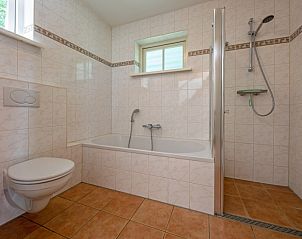 Ruime badkamer met bad en douche in 't Mienthuis - Jonkvrouw, De Dennen, Texel, ideaal voor ontspanning na een dag op de Waddeneilanden.