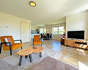 Moderne binnenruimte van Appartement Bos en Duin 43, De Dennen, Texel met ruime zithoek en eetgedeelte.